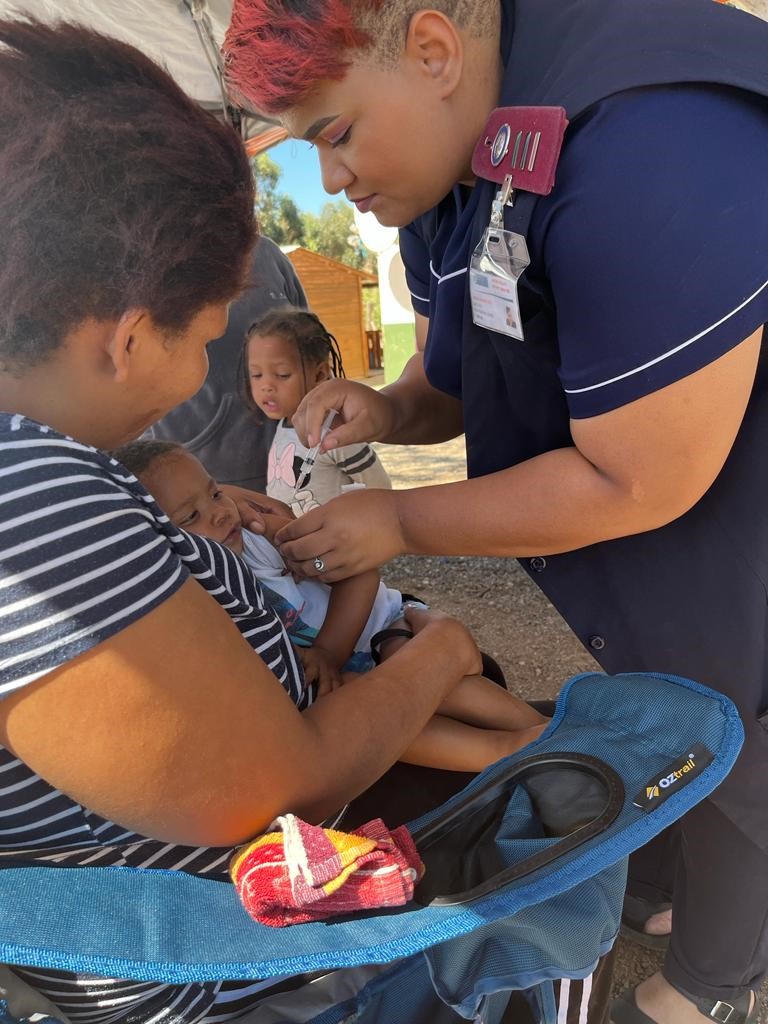 Sr Tamlin Sibole vaccinates Misokuhle Gertse during the outreach.