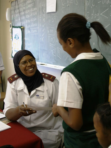 Sr Aqueela America checking a young girl's consent form for HPV vaccination 