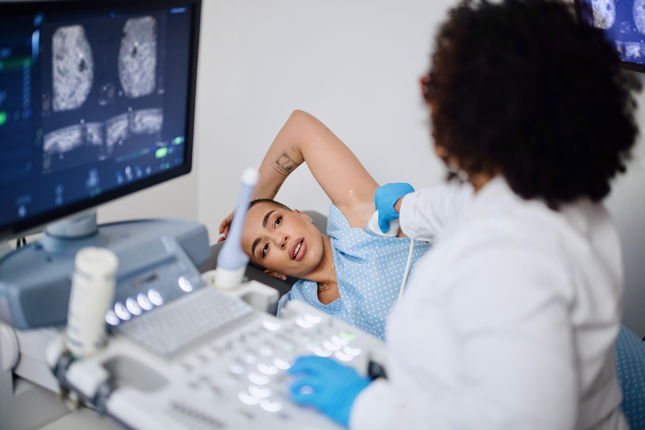 A young woman getting an ultrasound breast exam