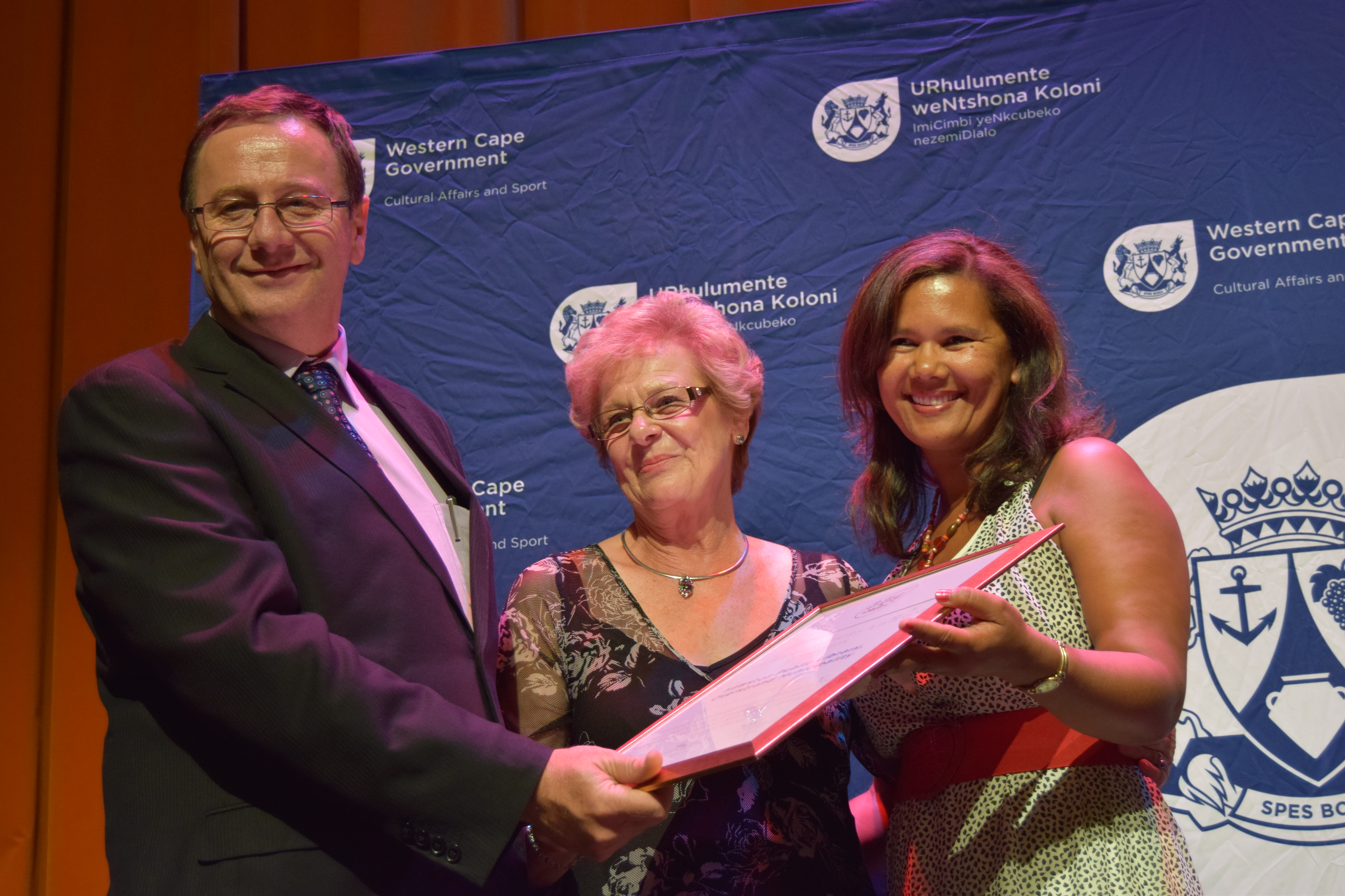 Minister Anton Bredell handing over a Ministerial Award to representatives of Hawston Public Library 