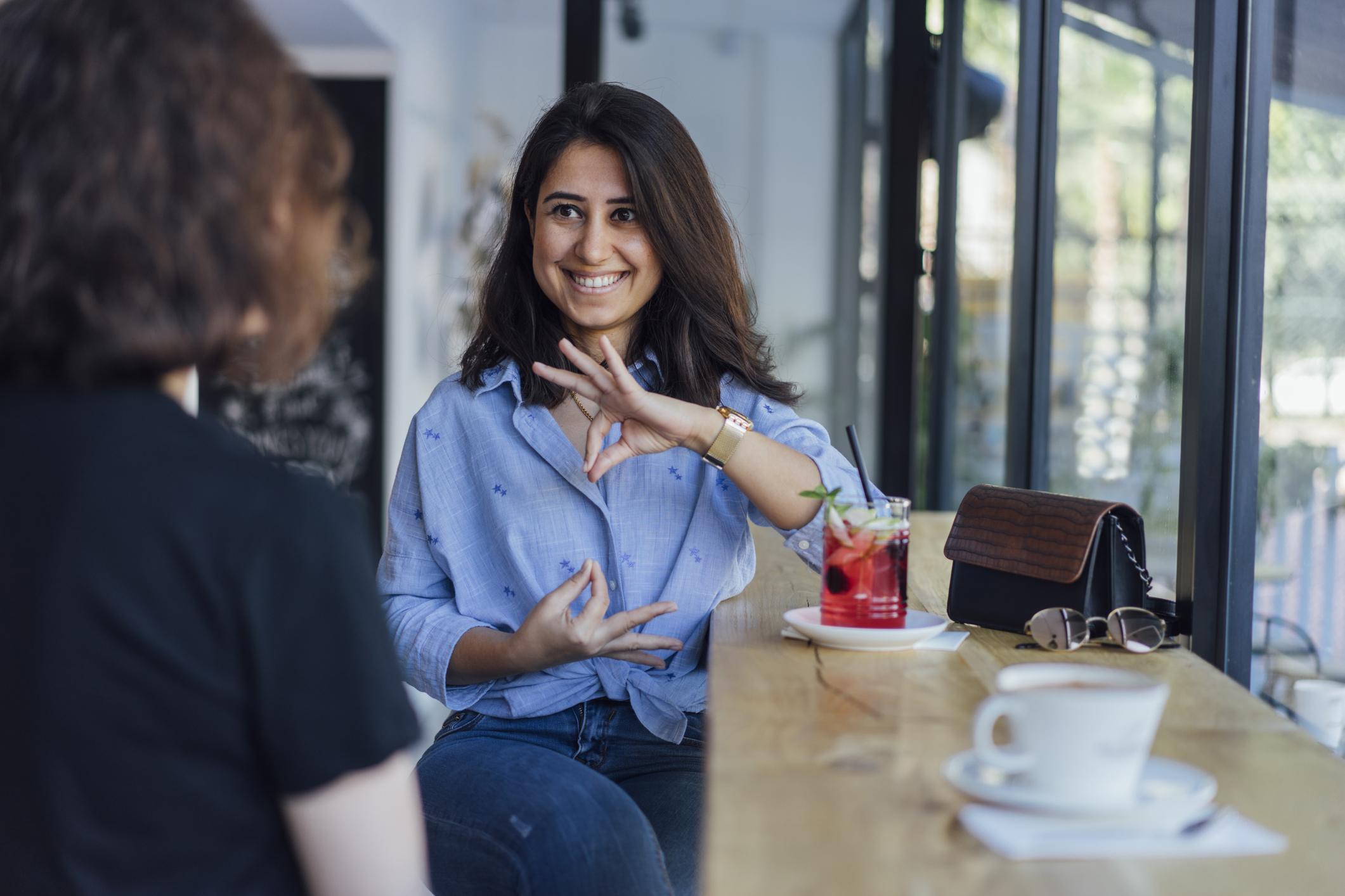 Two young women speak in sign language 