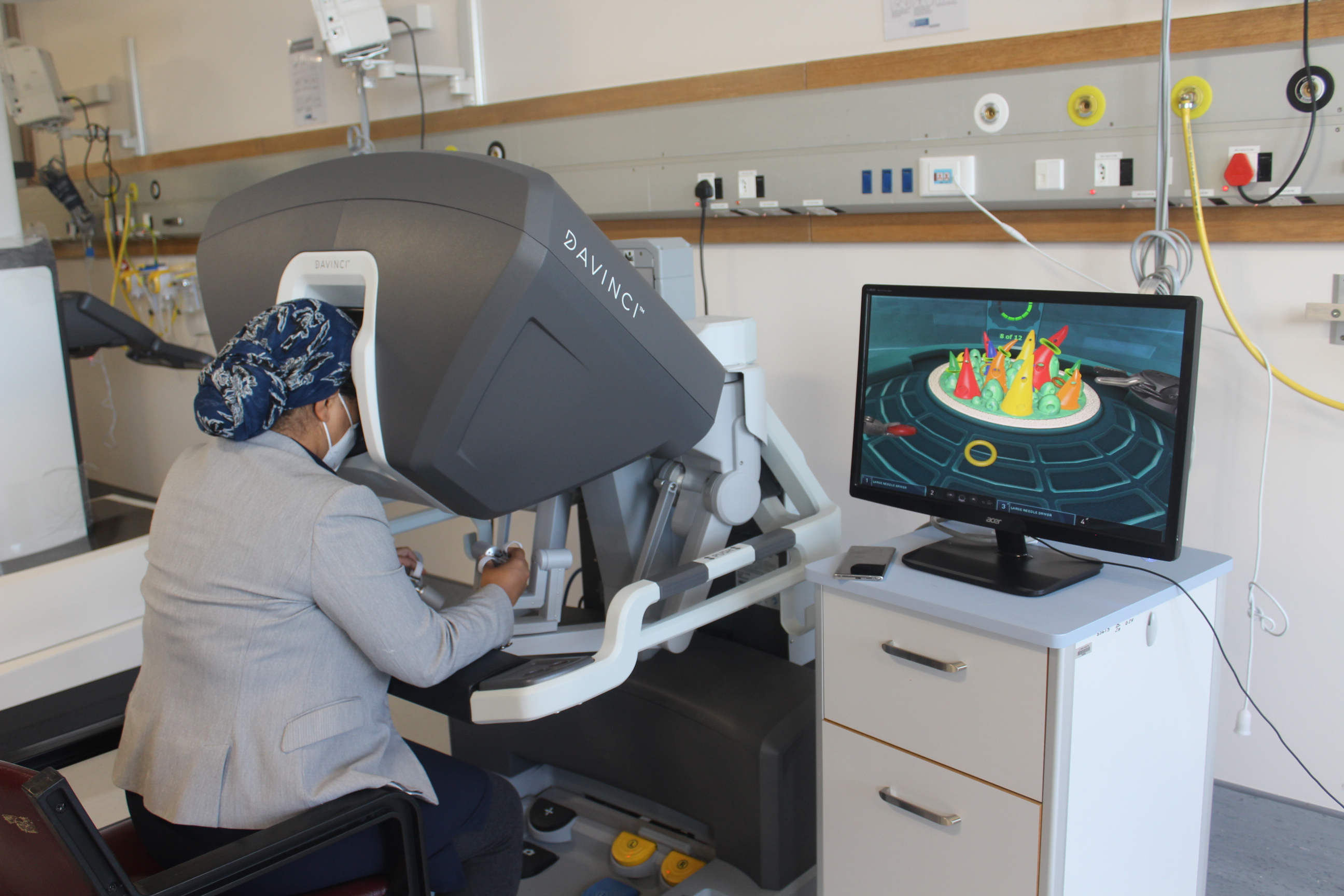 A Doctor is controlling the robot as part of robot surgery.