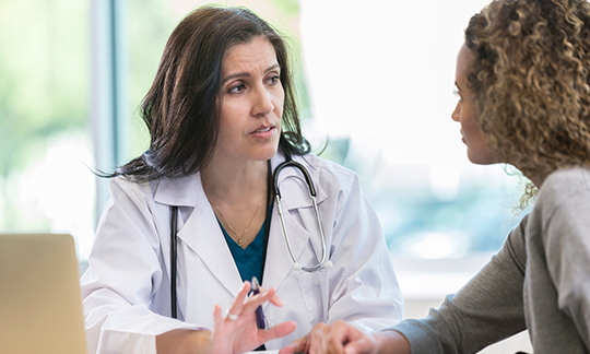 Dr talking to a-female patient.