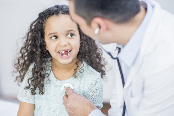 Dr checking young girl's hear rate