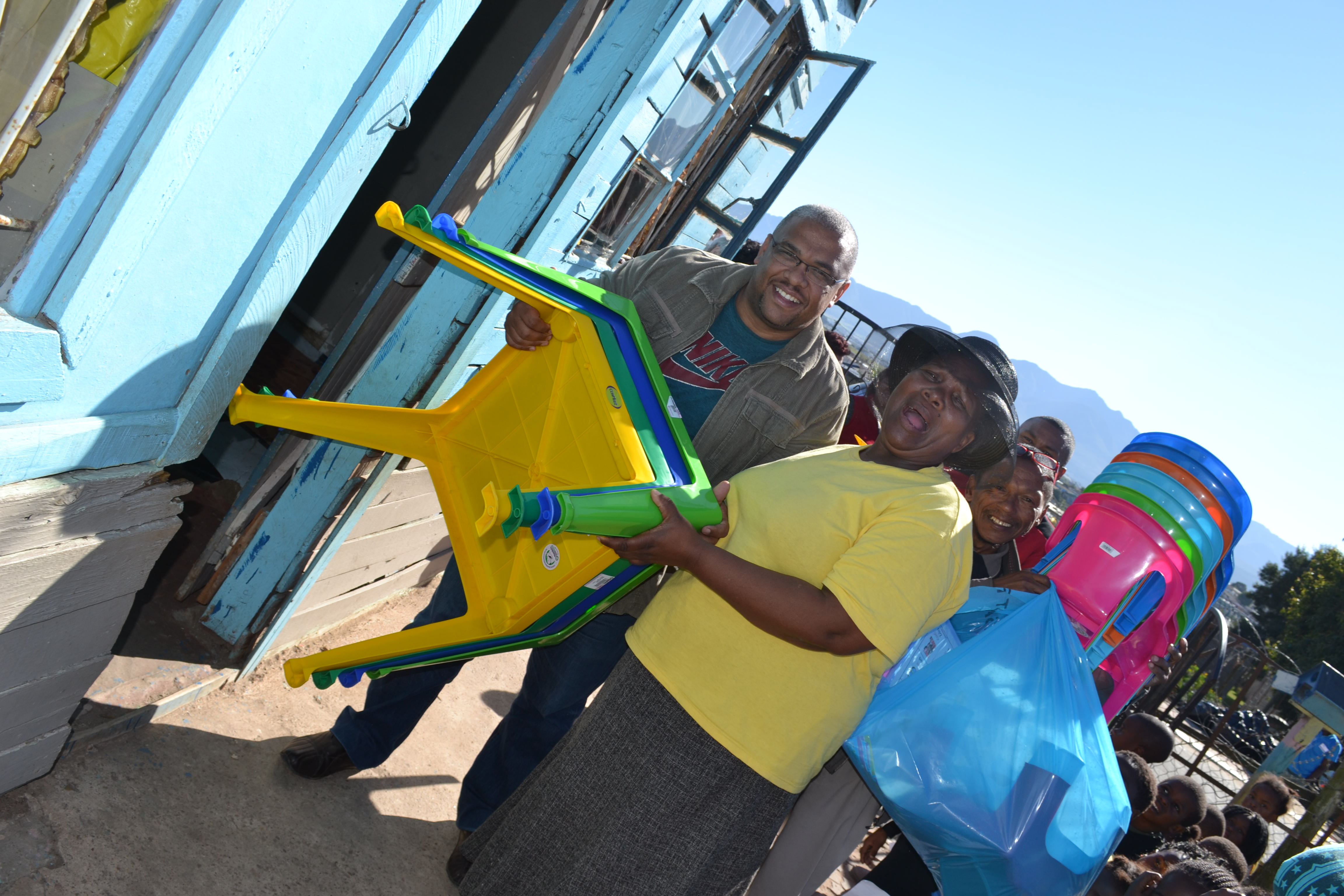 Customer Care officer, Willbert Josephs handing over the gifts to the Principal of Lihle ECD Centre