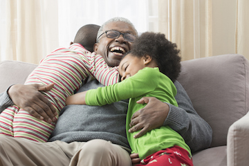 Happy grandad playing with grandkids on the couch