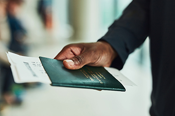 Man holding his passport in his hands, ready to board his flight. 