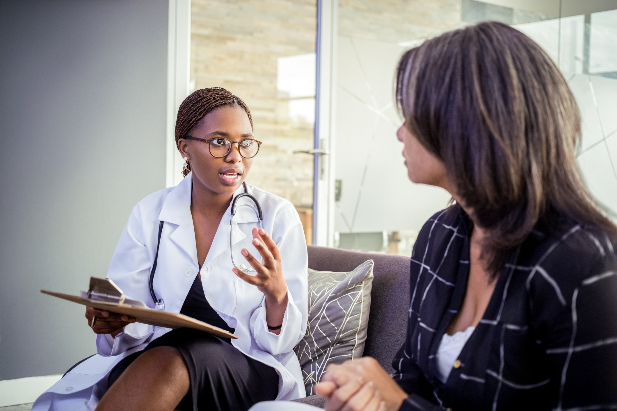 Female doctor doing medical exam of a woman patient in clinic. Healthcare professional discussing treatment with woman in hospital.