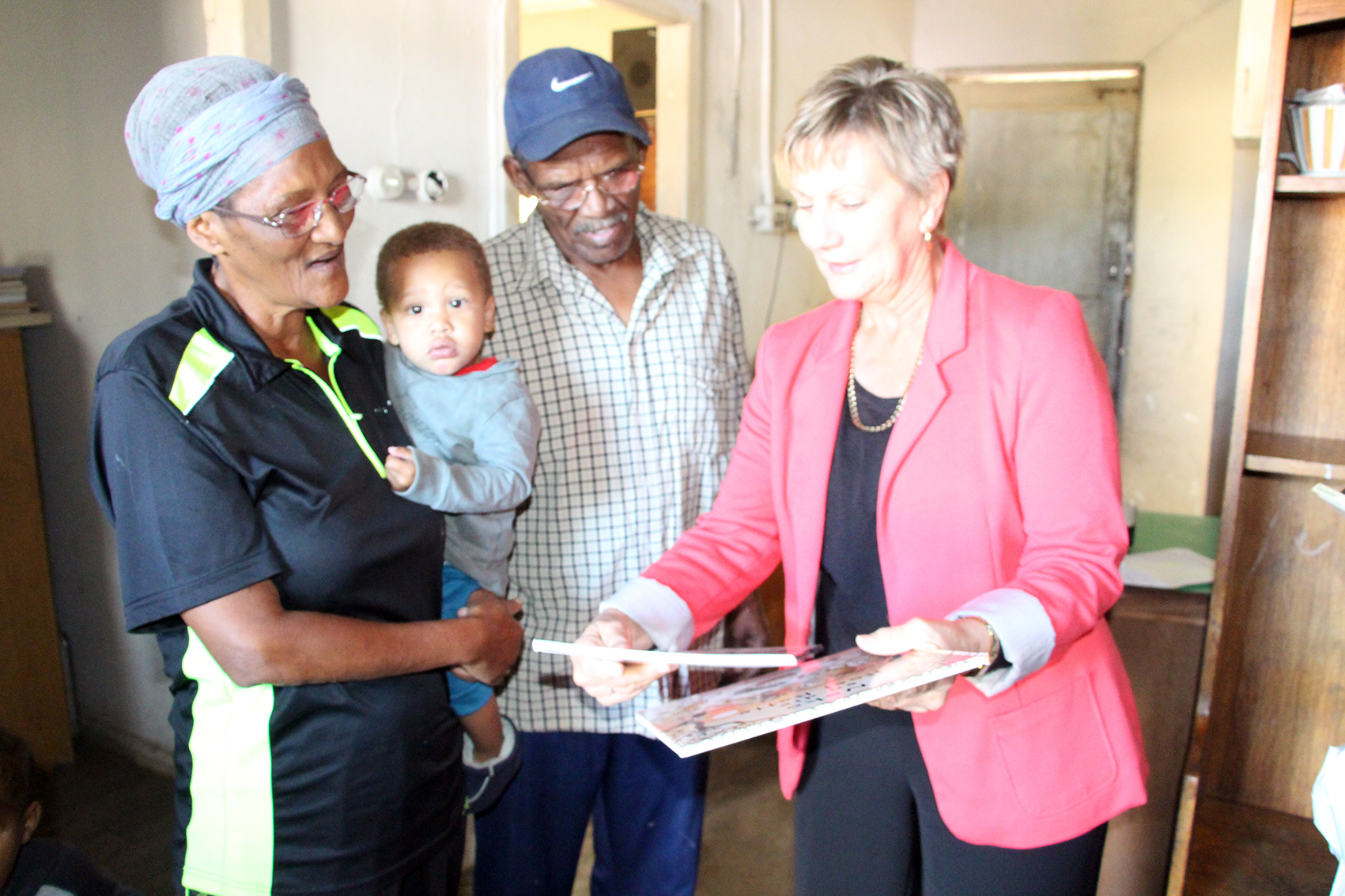 Minister Anroux Marais handing over books to the Cupido family