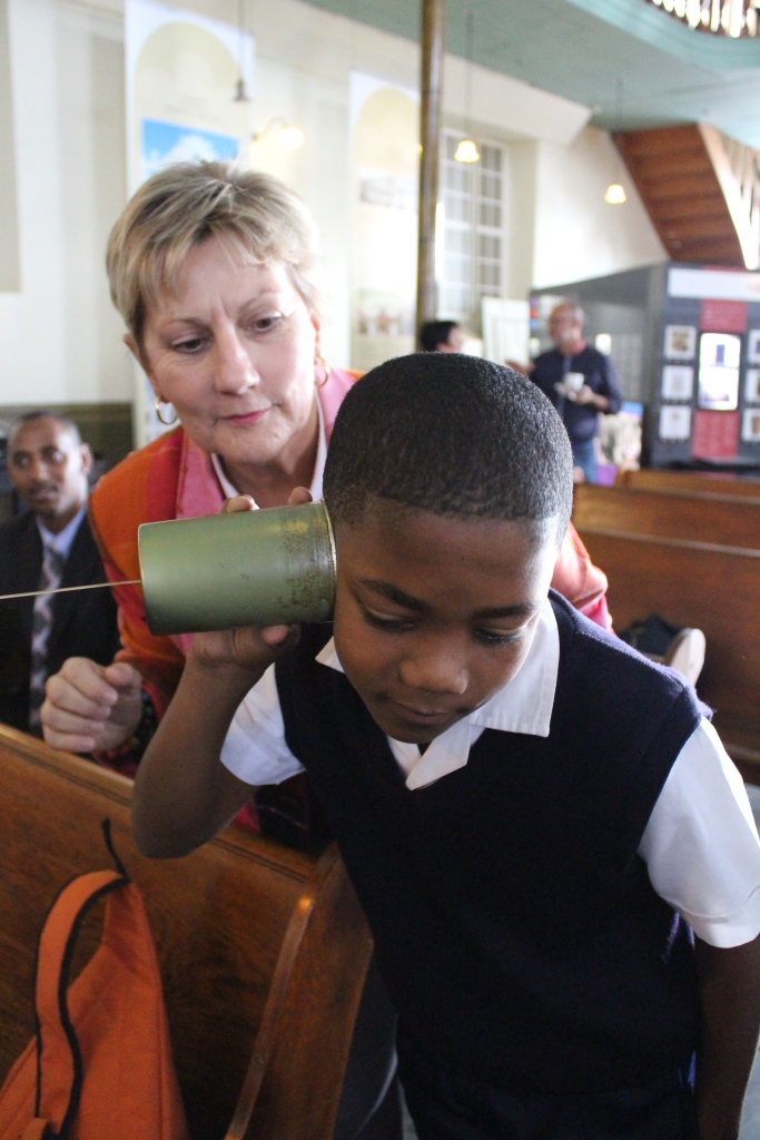 Minister Marais helps one of the learners with the telephone toy