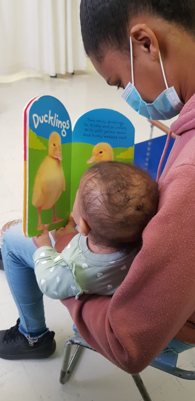 A mother reads to her little one during one of the sessions provided as part of WCGHW OT service.