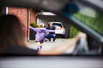 Blurred out mommy in car drops daughter at her daddy's house. Daughter running to daddy with his arms wide open and smiling.