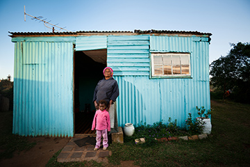 Mother and daughter standing in front of their house