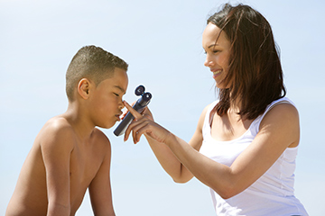 mother-putting-sunblock-on-her-son