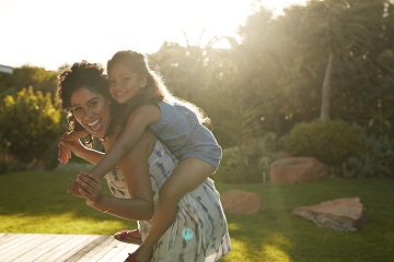 Mom carrying daughter on back