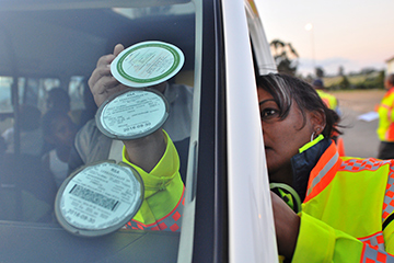 traffic officer placing sticker inside wind screen