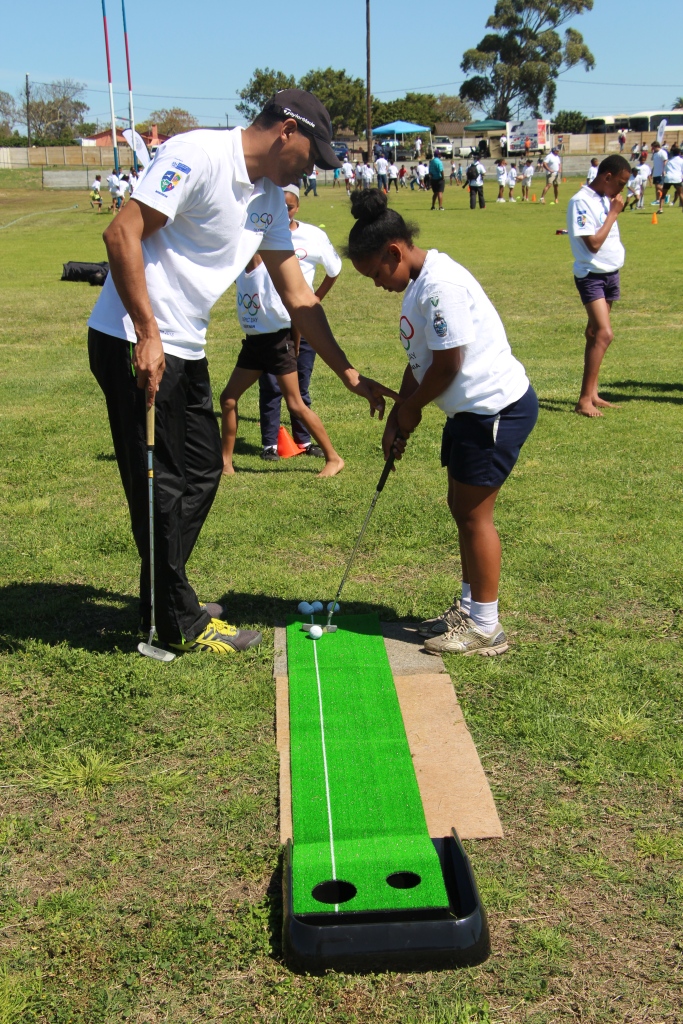 One of the youth being showed how to throw a javelin