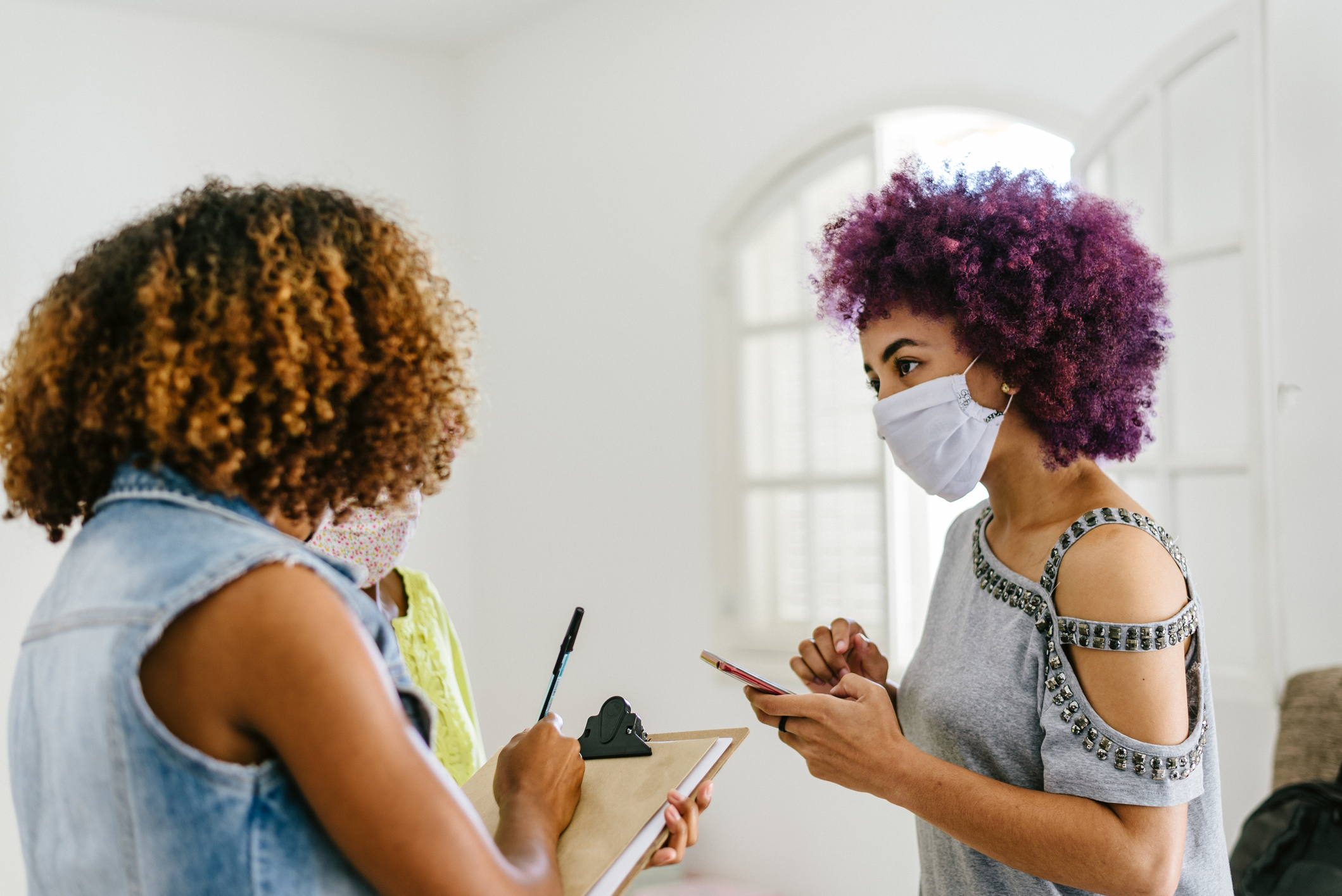 young women talking to each other with masks on